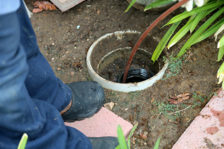 Sewer cleaning. A plumber uses a sewer snake to clean blockage i